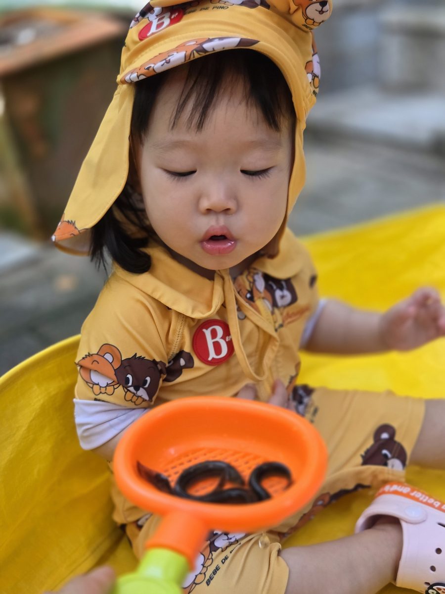 뜰채 속 미꾸라지를 보고 놀란 표정을 짓는 아이