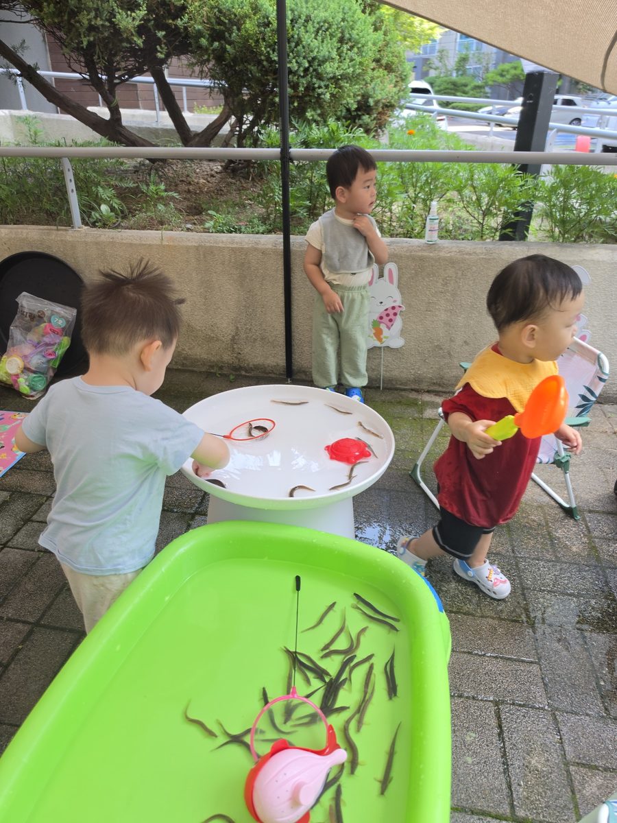 친구들과 나란히 서서 미꾸라지를 잡아보는 1세반 아이들