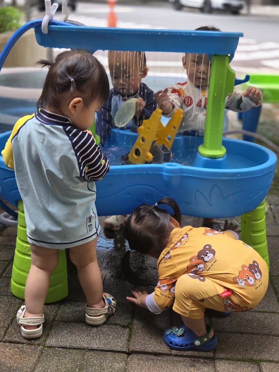 물놀이 테이블 앞에서 물줄기를 손으로 만져보는 아이