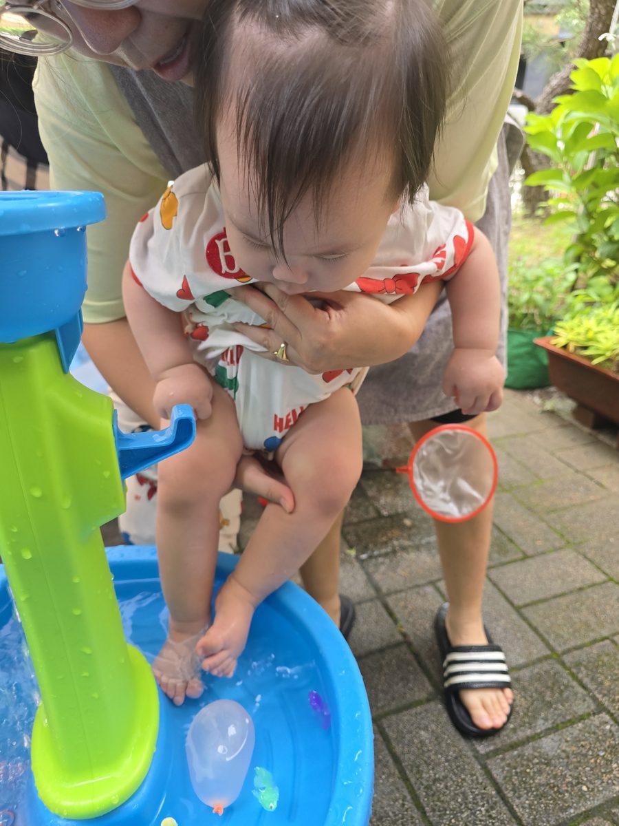 선생님 품에 안겨 발끝으로 물을 느껴보는 0세반 아이