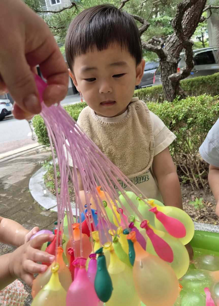 물풍선 다발을 가까이에서 바라보는 아이