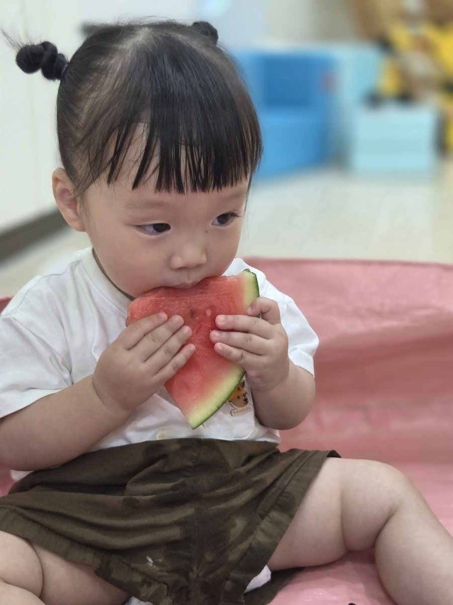 아이가 수박 조각을 맛보는 모습